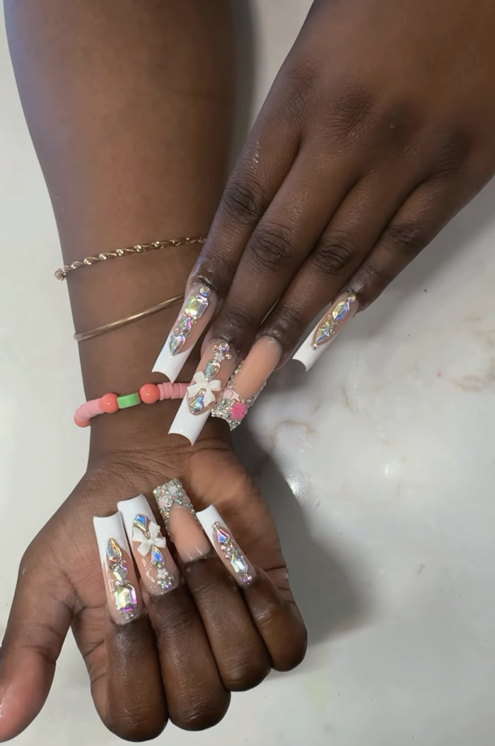 Long coffin nails with iridescent crystals, 3D bows and pink glitter accents