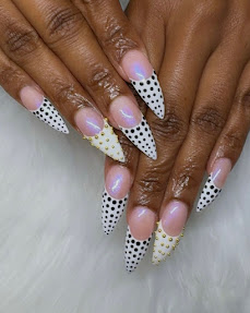 Nude stiletto nails with black polka dot tips